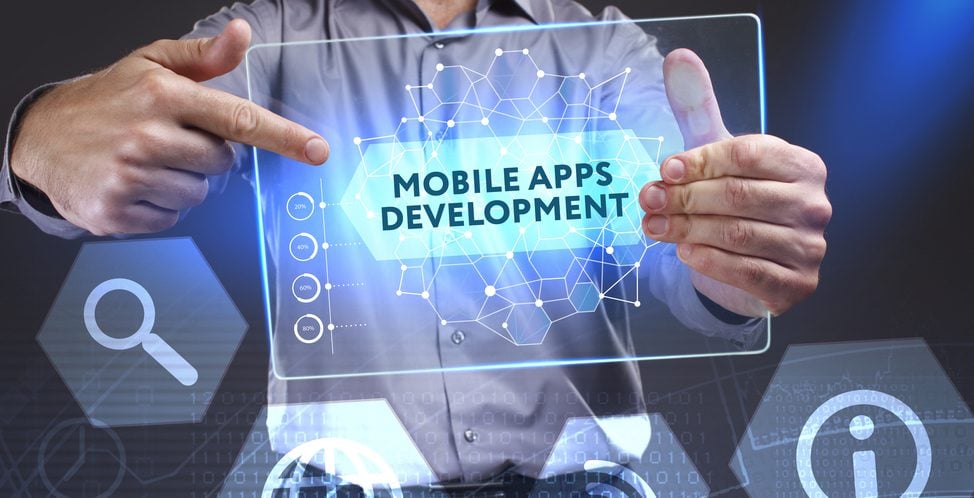 Man pointing at a table displaying the words "Mobile app development"