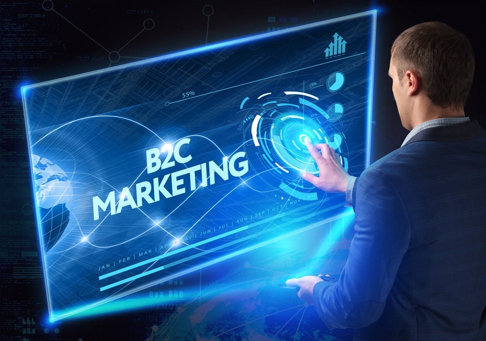 Business man interacting with a digital board displaying the words B2C Marketing
