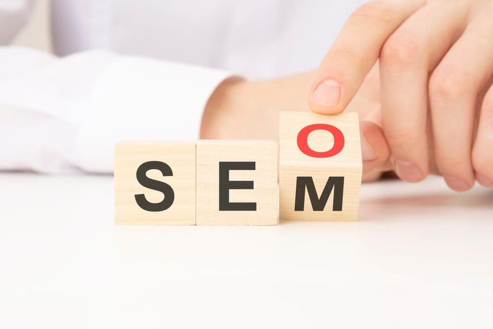 seo sem_hand change wooden cube block from SEO to SEM, white background. marketing and strategy concepts.