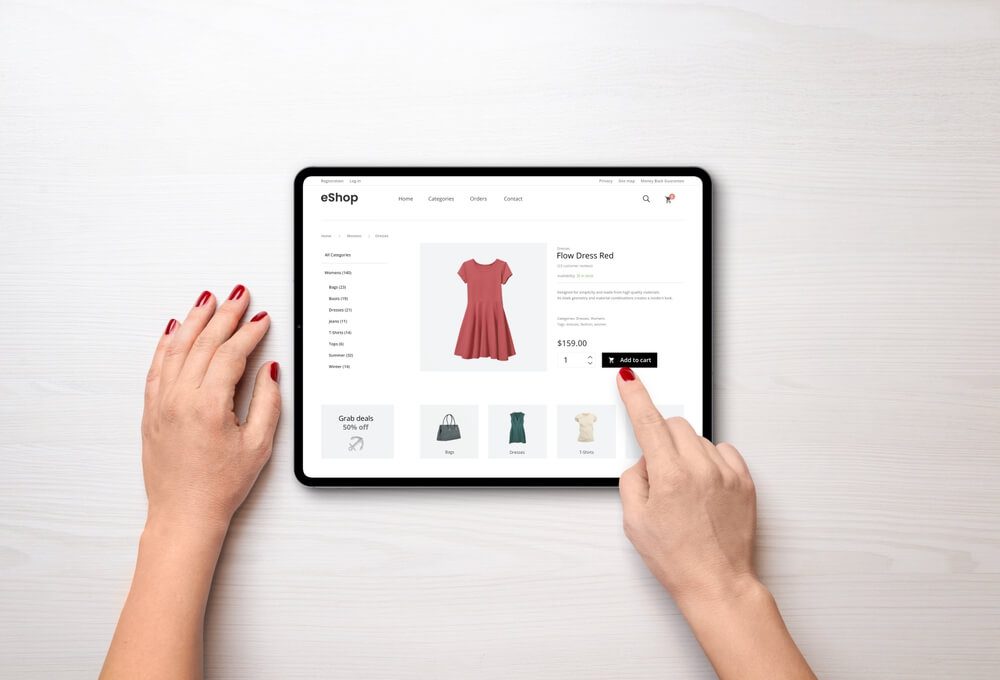 eCommerce_Online shopping with a tablet. Red women's dress on the e-commerce web page