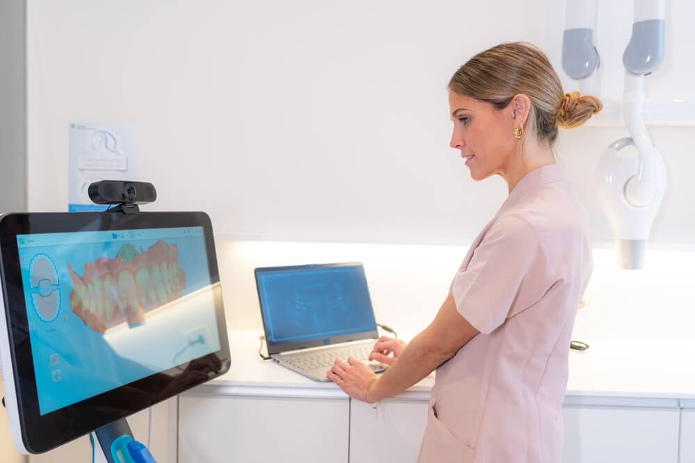 AI dentist_Technician using modern technology to analyse the scan results in a clinic