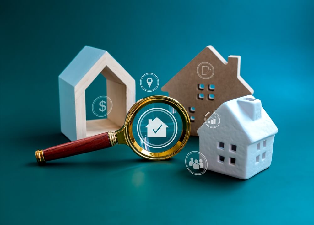 real estate_House online search, Property value, home buying and selling, real estate investment concepts. Home and and valuable research icons in magnifying glass with three types of house on blue background.