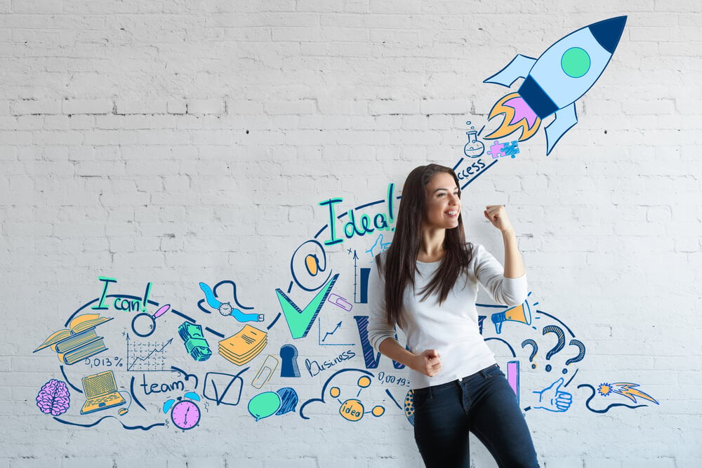 marketing success_Attractive european woman celebrating success on brick wall background with creative drawn space ship. Successful young entrepreneur