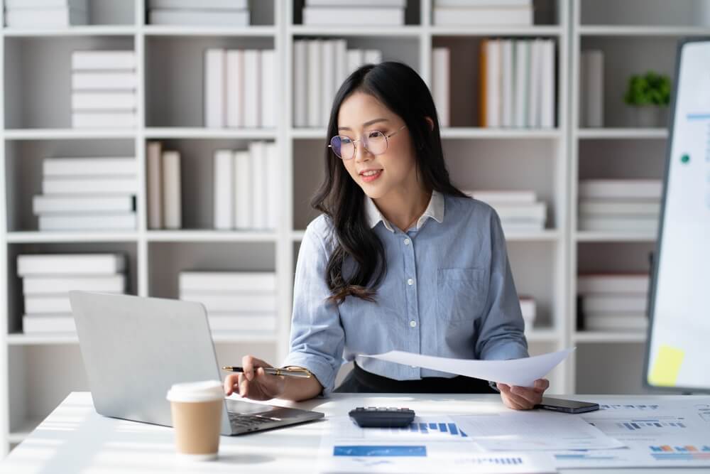 revenue officer_Portrait of young beautiful Asian businesswoman working in her office room.