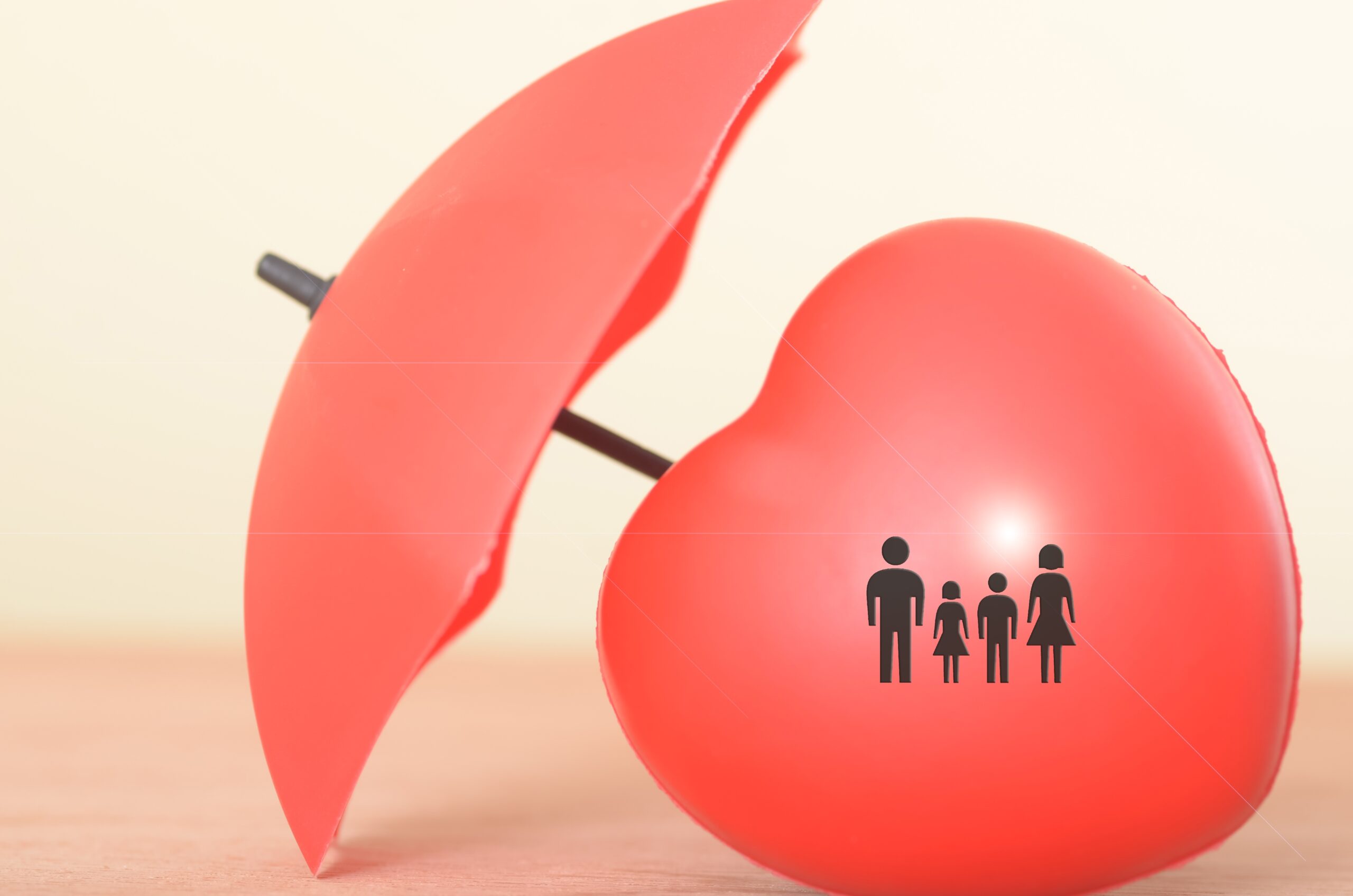 A family of 4 is one a red heart protected by the red umbrella put there by a Chicago FCMO for life insurance marketing