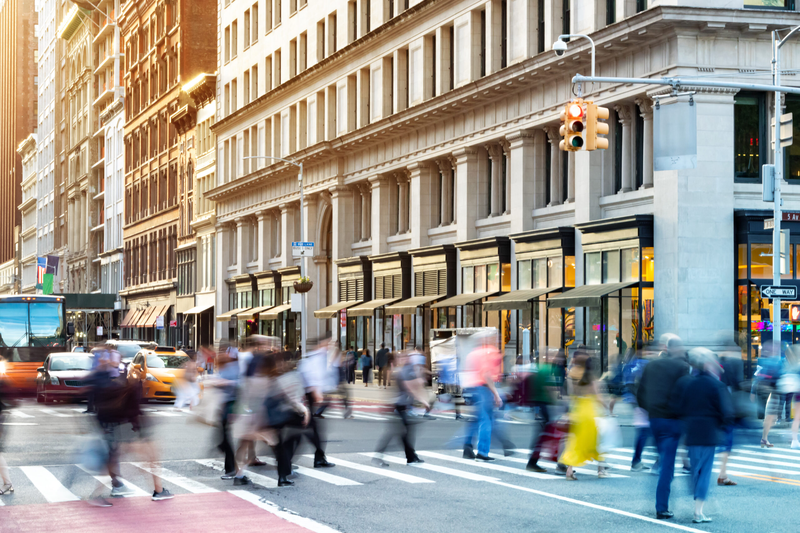 A New York FCMO for retail marketing walks among the blurred, hurried crowd in on a NY city street at sunset