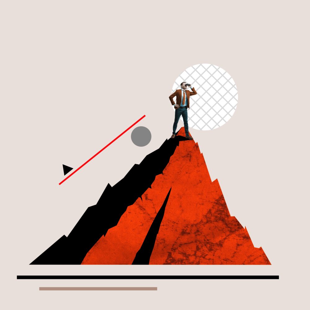 A businessman in a suit stands on a red mountain, overcoming business challenges