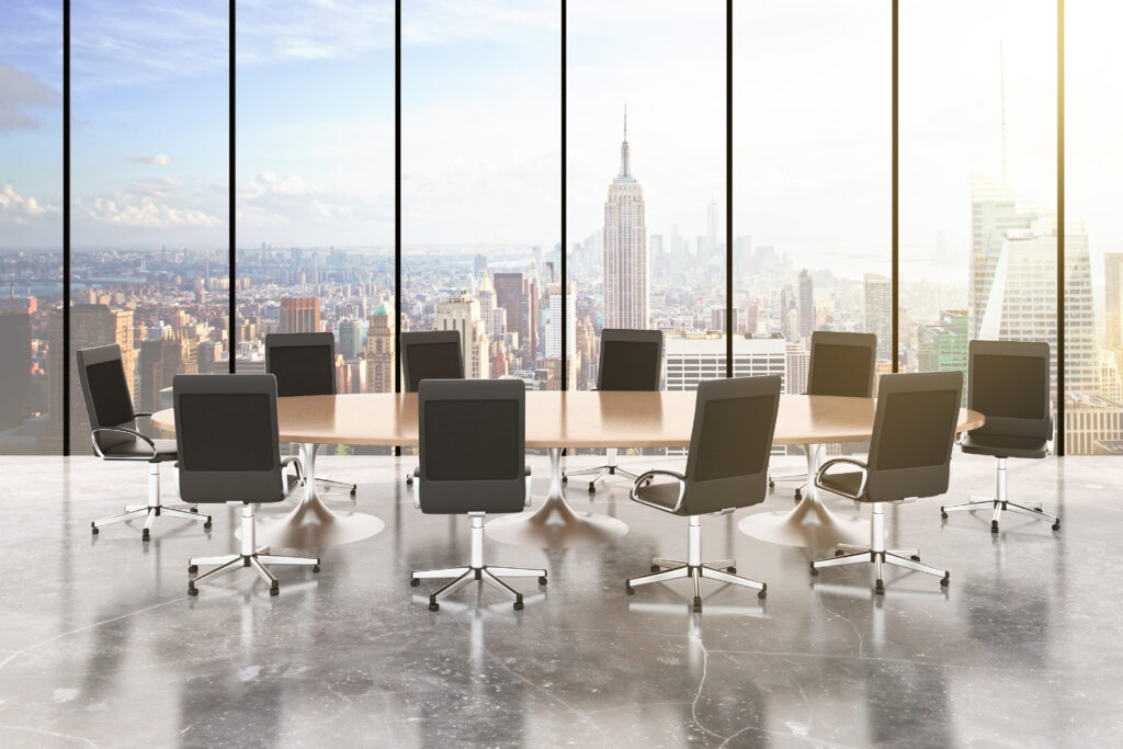 A conference table and chairs with the NYC skyline, representing a New York Fractional CMO Responsibilities of leading meetings