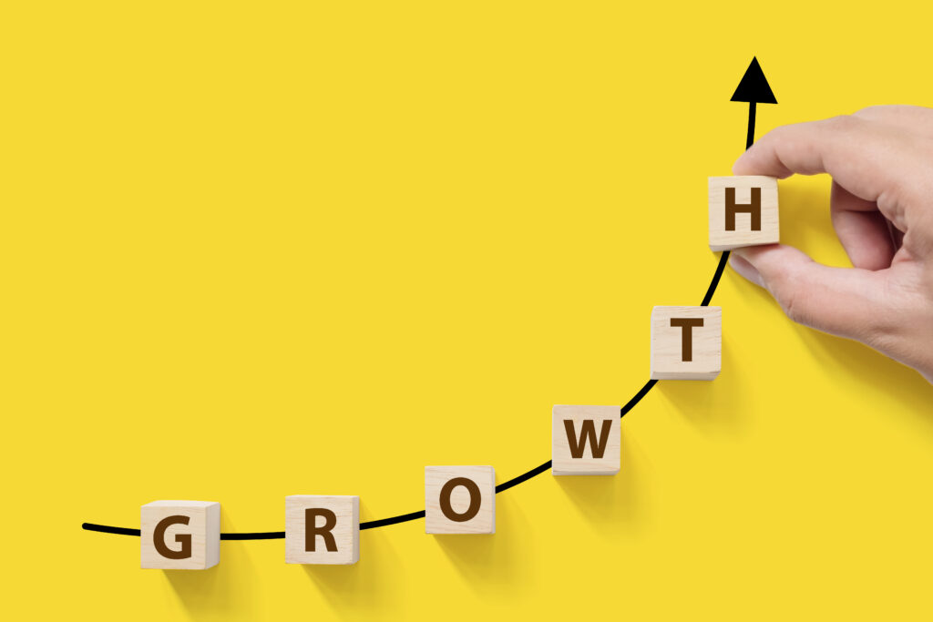 Wooden blocks spell "growth" over a yellow background with a black arrow for Acquisition Growth Marketing