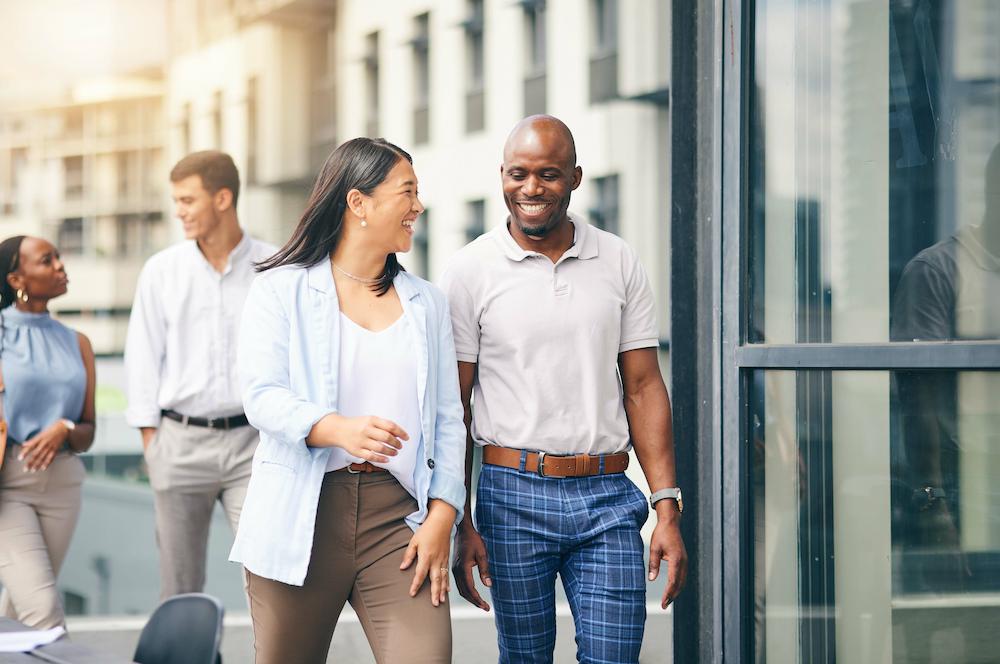 Two happy Atlanta social media marketing agency employees walk down the street into an office building