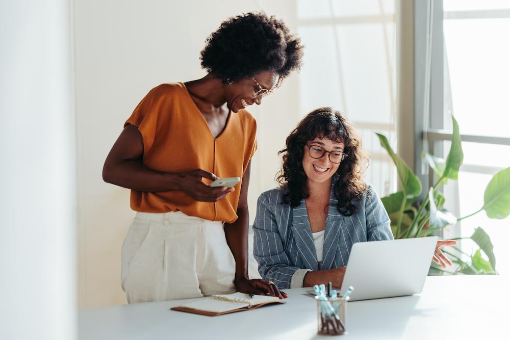 Two women at an Atlanta social media marketing agency look at a computer in an office