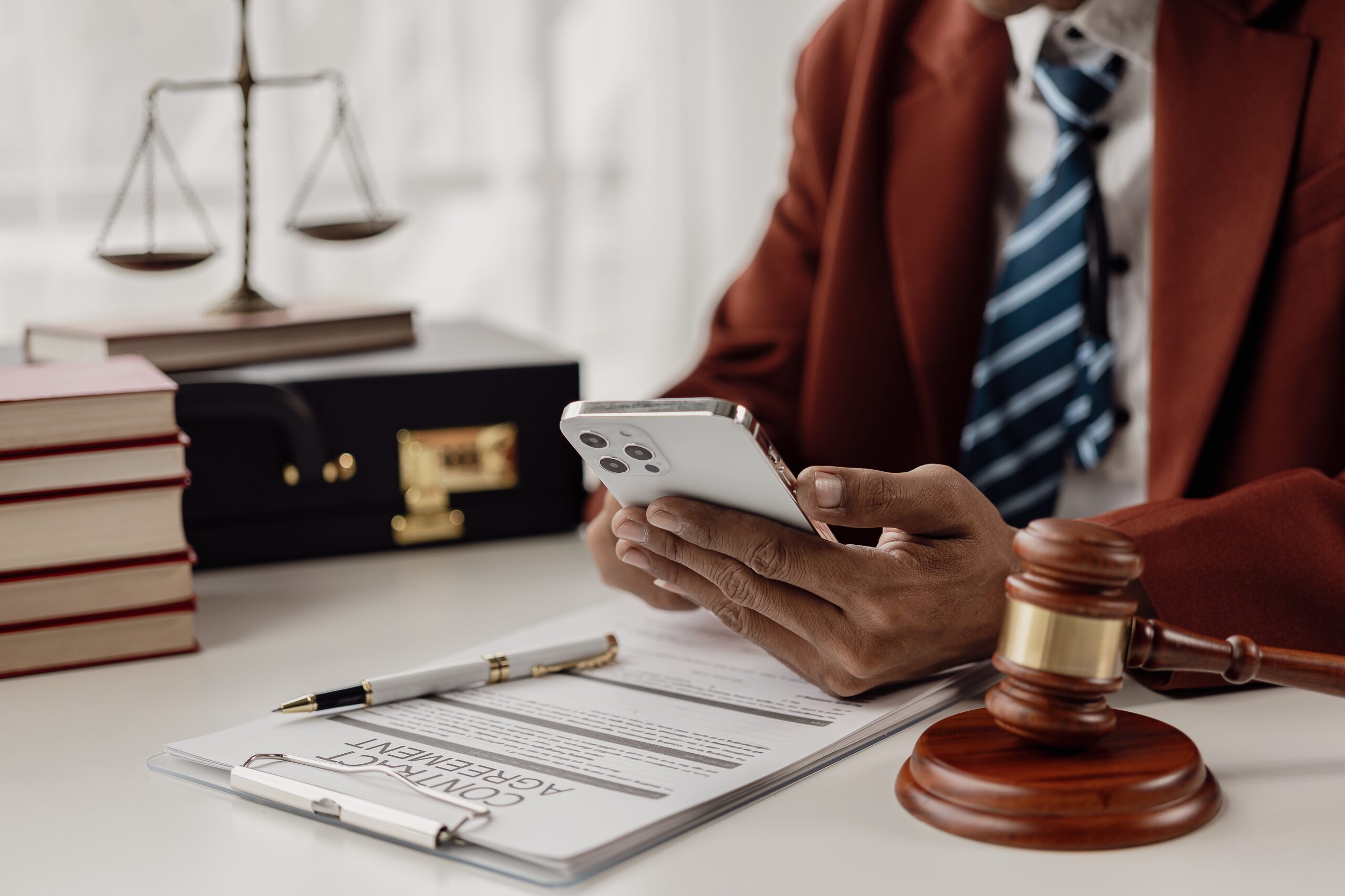 fractional cmo for personal injury lawsuit marketing holds a cell phone next to a judge's hammer