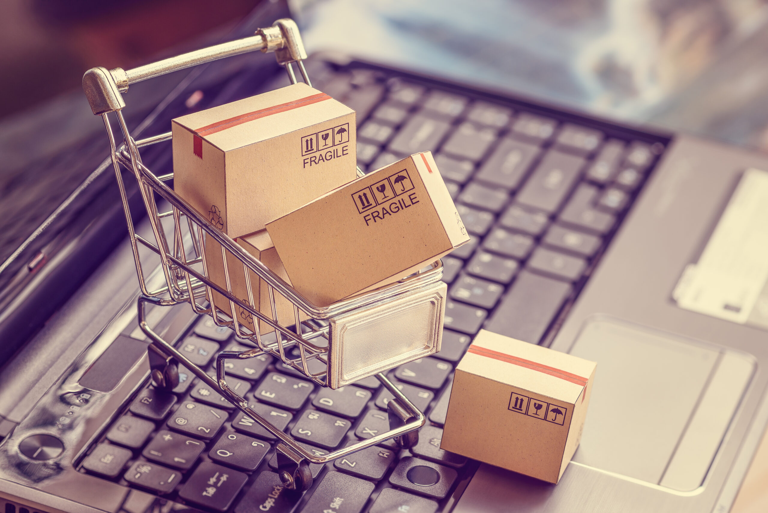 a mini shopping cart filled with cardboard boxes on a keyboard