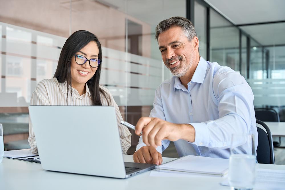 A B2B marketing consultant goes over a successful strategy with a happy client in an office.