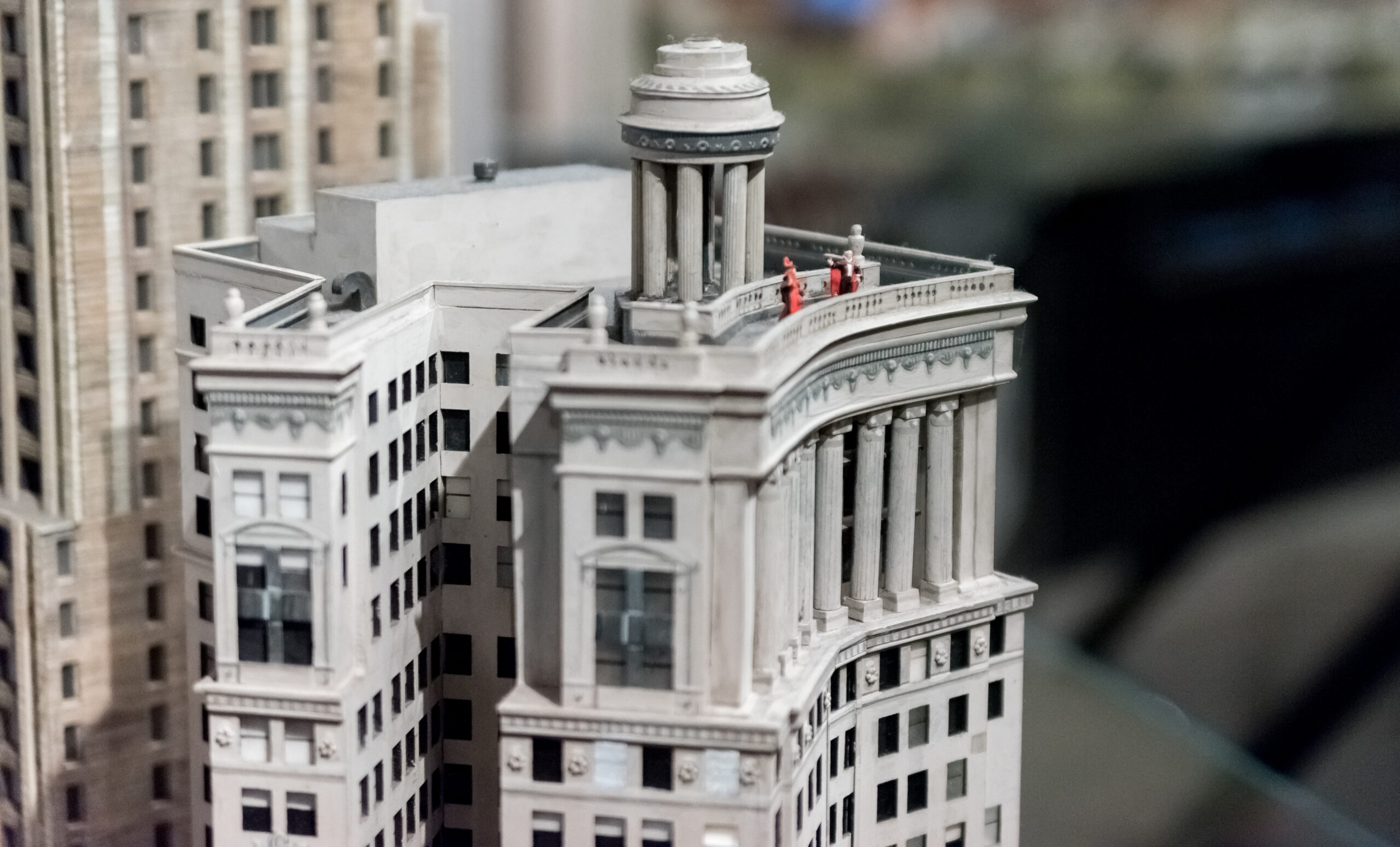 A miniature diorama of Chicago's white and gray city buildings with tiny people working in them